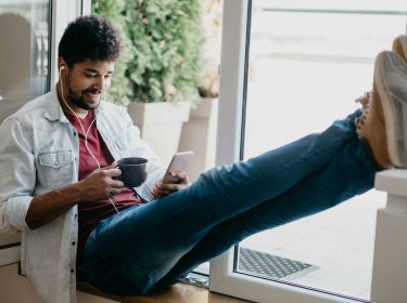 Junger Mann zockt via Smartphone.