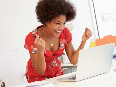 Junge Frau arbeitet am Laptop.