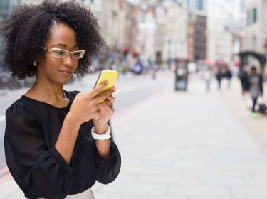 Junge Frau schreibt Nachrichten auf ihrem Smartphone.
