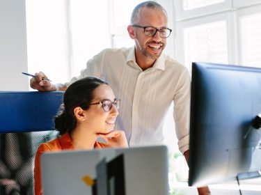 Zwei Kollegen verfassen über Gmail eine Mail an einen Geschäftspartner