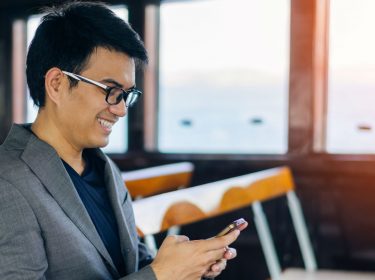 Junger Mann schaut HDR-Videos auf seinem iPhone.