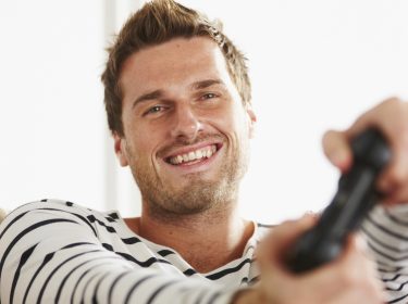 Ein junger Mann spielt PlayStation 4