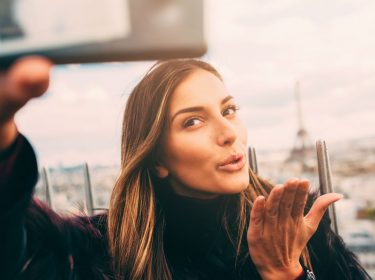 Junge Frau dreht Video mit dem Smartphone.