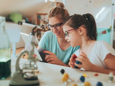 Mutter und Kind spielen am Tablet.