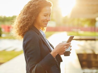 Frau schreibt einen Tweet auf ihrem Smartphone.