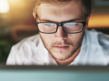 Junger Mann arbeitet am Windows-10-PC.