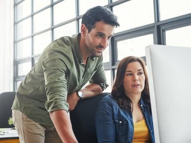 Kollegen arbeiten am Mac.