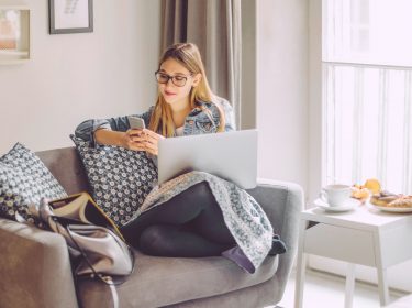 Junge Frau nutzt ihr Smartphone, um ihr Firefox-Konto zu schützen