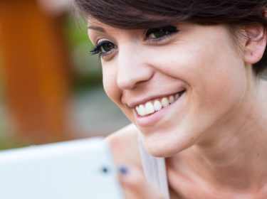 Eine junge Frau spielt Android-Spiele auf ihrem Smartphone