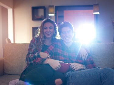 Ein junges Pärchen schaut einen Film über den Beamer
