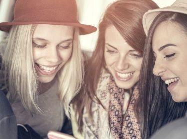 Drei Freundinnen diktieren eine WhatsApp-Nachricht.