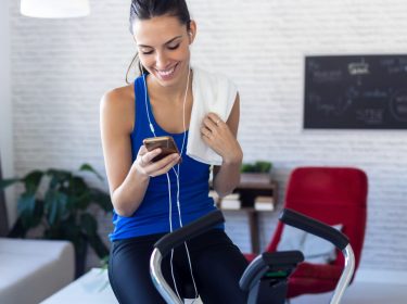 Frau nutzt Samsung Health am Handy, während sie Sport macht.