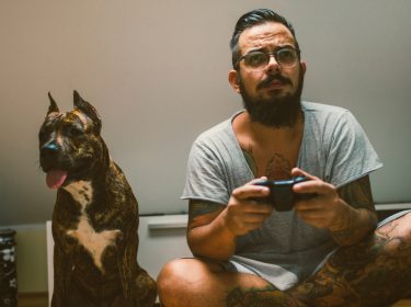 Mann mit Hund beim Zocken