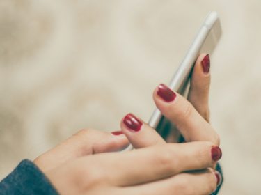 Junge Frau löst ihre iMessage-Probleme am Smartphone.