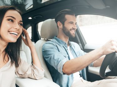 Ein junges Pärchen fährt mit dem Auto und navigiert über Google Maps