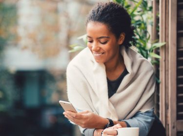 Junge Frau entdeckt am Smartphone die neue Google-Funktion