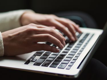 Frau arbeitet am Macbook