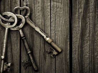 Alte Schlüssel, die an einer Tür hängen