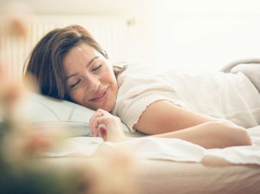 Junge Frau schläft im Bett.