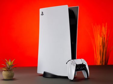 PlayStation 5 und Controller vor rotem Hintergrund