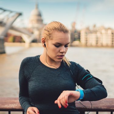 Frau mit Smartwatch beim Joggen am Wasser Frau mit Smartwatch beim Joggen am Wasser