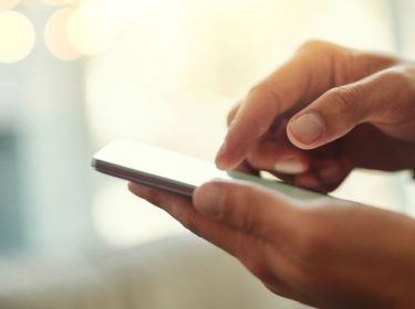 Junger Mann nutzt iOS 12 am iPhone.