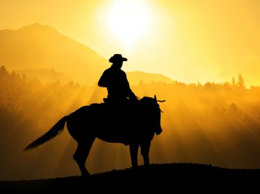 Junger Outlaw reitet auf dem Pferd durch den Wilden Westen.