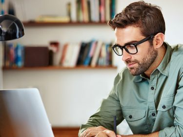 Junger Mann nutzt Gmail am Laptop.