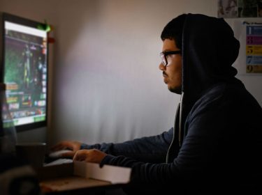 Junger Mann zockt ein PC-Spiel.