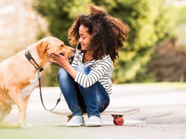 Ein junges Mädchen spielt mit einem Hund