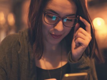 Frau richtet für Siri am Smartphone einen Kurzbefehl ein.