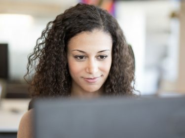 Junge Frau löst das Problem mit ihrem PC-Bildschirm und arbeitet weiter.