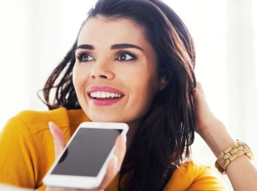 Frau nutzt neue Google-Assistant-Funktion am Smartphone.