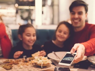 Mann bezahlt bargeldlos mit Apple Pay für das Essen.