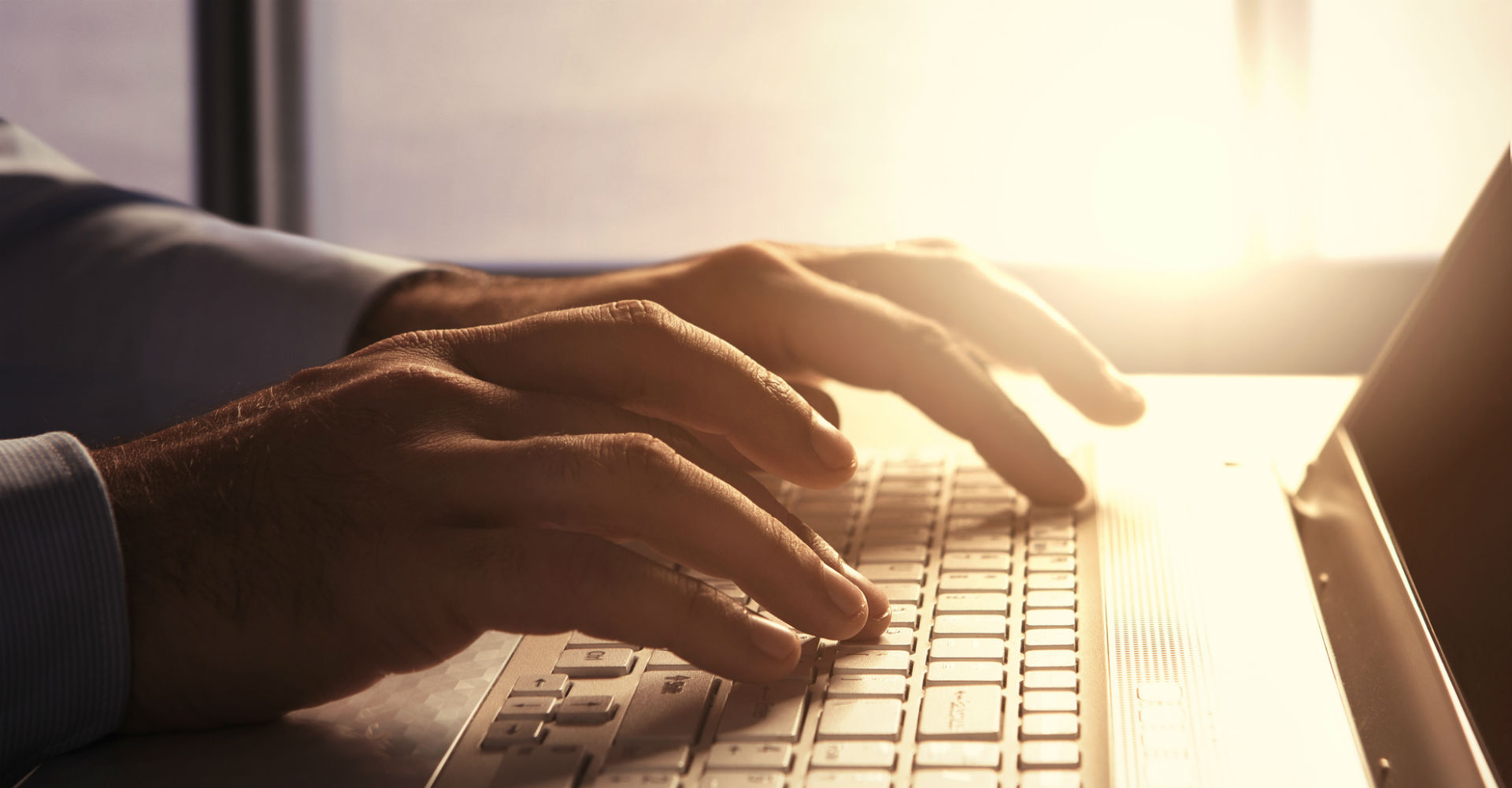 Mann tippt auf der Tastatur seine MacBooks.