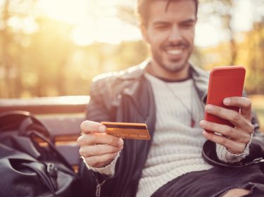 Junger Mann checkt sein Apple-Pay-Konto