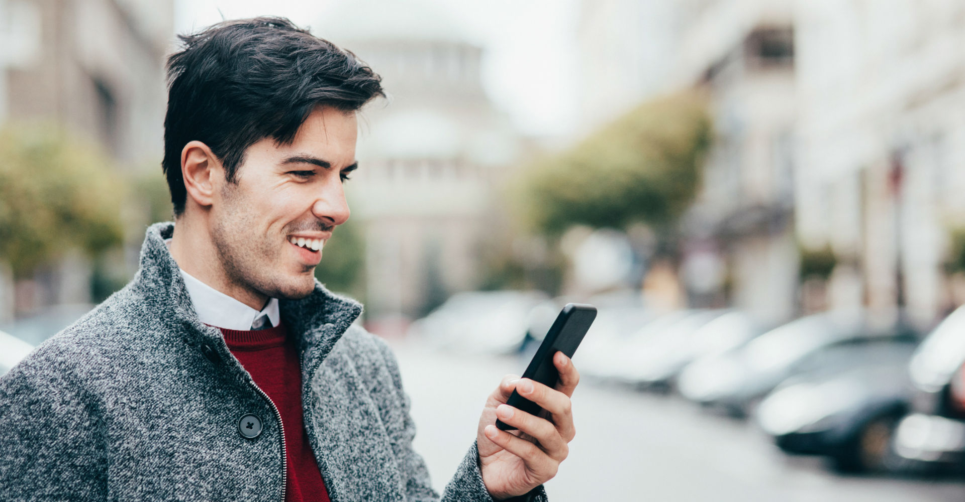 Junger Mann navigiert am Smartphone mit Google Maps.