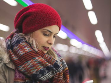 JUnge Frau schaut auf ihr Smartphone.