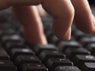 Weibliche Hand tippt Sonderzeichen