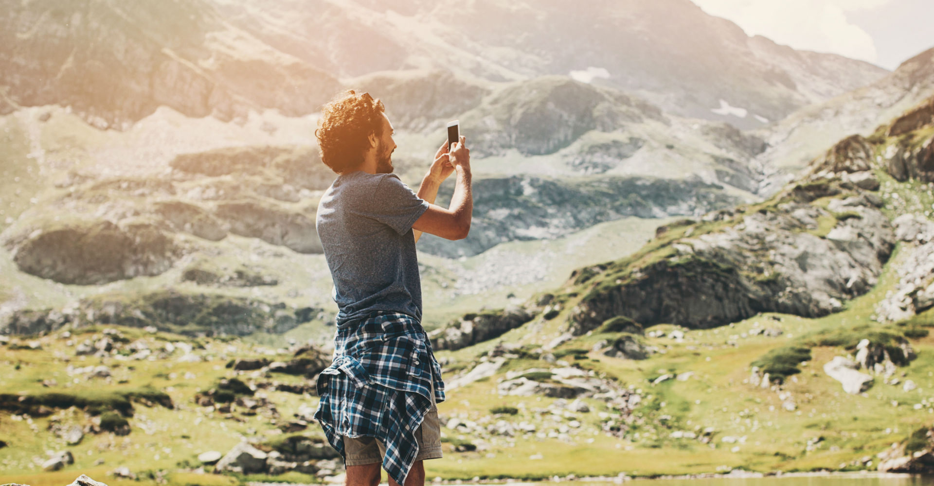 Junger Mann nimmt mit dem Smartphone ein Foto auf.