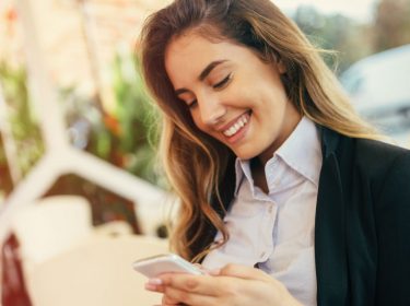 Junge Frau sieht die chronologische Twitter-Timeline auf ihrem Smartphone ein.