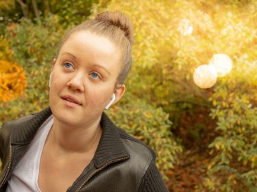 Junge Frau hört Musik mit den neuen AirPods.