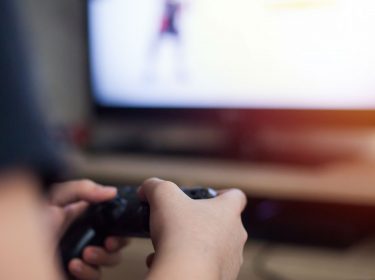 Junger Mann zockt Apex Legends mit Controller.