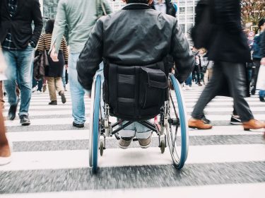 Rollstuhlfahrer unterwegs im Straßenverkehr