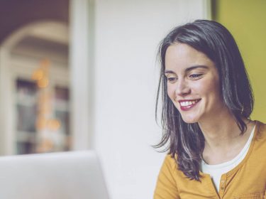Junge Frau nutzt Google-Chrome-Erweiterung am Laptop.