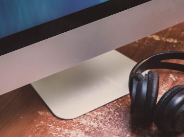 Bluetooth-Kopfhörer liegt neben einem Mac.