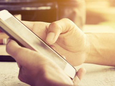 Auf dem Display des Smartphones mithilfe von SwiftKey etwas eintippen.