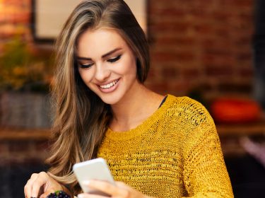 Junge Frau lädt sich eine neue App herunter