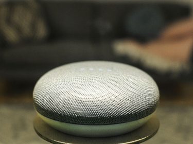 Ein Google-Home-Lautsprecher steht im Wohnzimmer.
