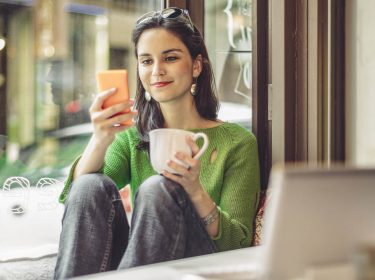 Junge Frau ändert am iPhone die iTunes-Bezahlmethode zu PayPal.